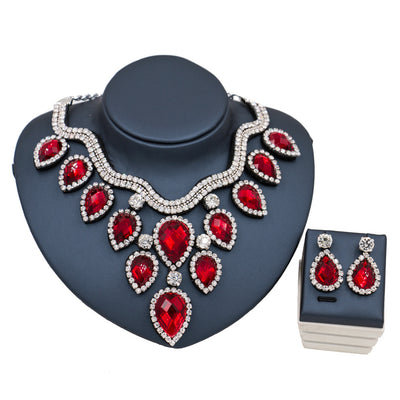 Colorful exaggerated bride necklace and earring set with large teardrop rhinestones on a dark display. - Image 12