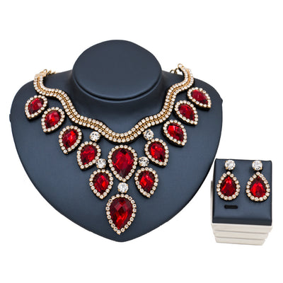 Colorful exaggerated bride necklace and earring set with large teardrop rhinestones on a dark display. - Image 7