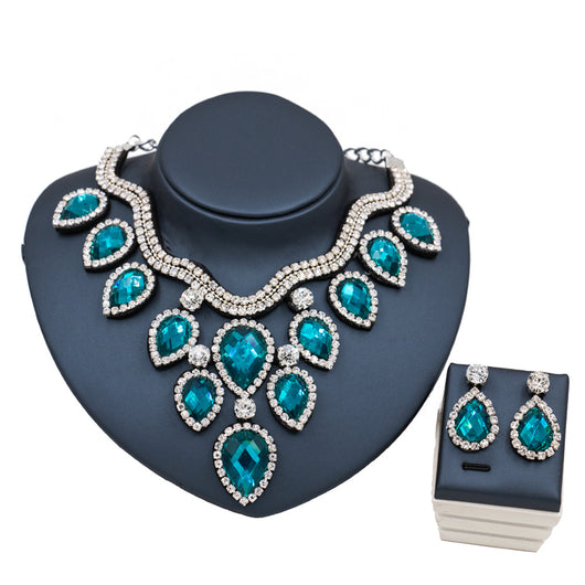 Colorful exaggerated bride necklace and earring set with large teardrop rhinestones on a dark display. - Image 11