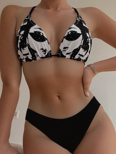 Black and white printed triangular cup tie bikini top with solid black bottoms, displayed with a knit tote bag and sunglasses. - Image 11