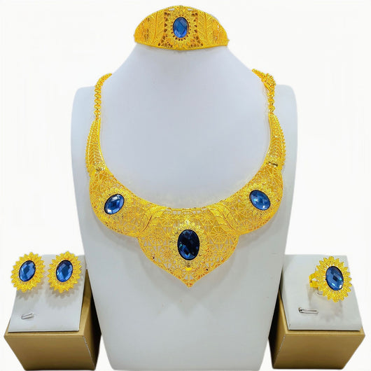 Golden jewelry set with a wide necklace, cuff bracelet, stud earrings, and ring, all featuring blue oval gemstones and intricate filigree patterns. - Image 4