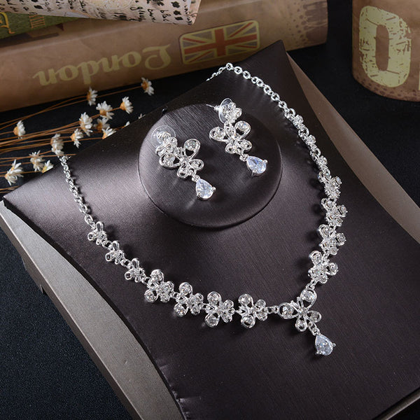 Silver-tone rhinestone necklace and pierced drop earrings set with floral and teardrop designs, ideal for bridal wear.