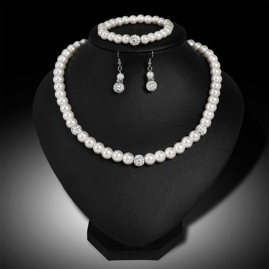 White faux pearl necklace, bracelet, and dangle earrings set with pave crystal beads on a black display. - Image 6