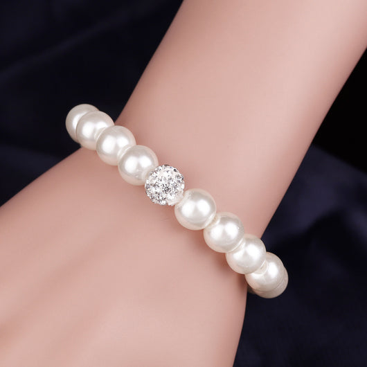 White faux pearl necklace, bracelet, and dangle earrings set with pave crystal beads on a black display. - Image 5