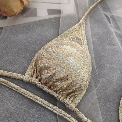 Woman wearing a shimmering gold one-piece swimsuit with a halter neck, crisscross straps, and stylish cut-out details. - Image 6