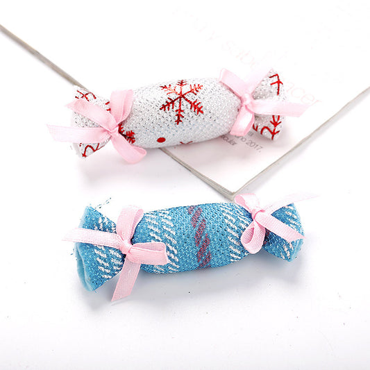Six colorful fabric pet toys shaped like wrapped candies, featuring plaid, polka dot, and snowflake patterns.