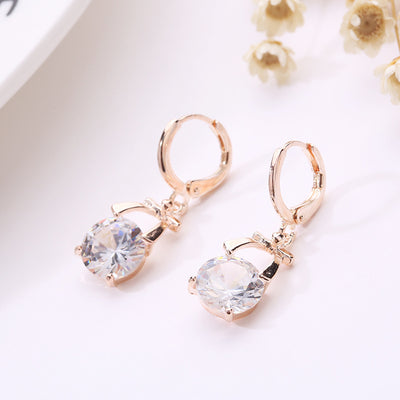 Rose gold-toned jewelry set with a necklace and matching dangle earrings, each featuring a round clear crystal. - Image 5