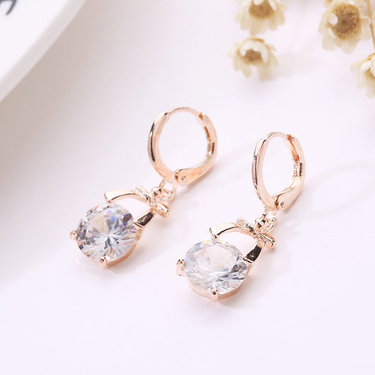 Rose gold-toned jewelry set with a necklace and matching dangle earrings, each featuring a round clear crystal. - Image 5