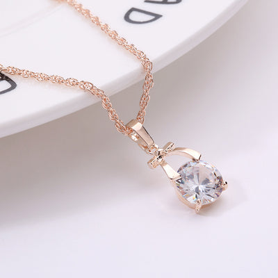 Rose gold-toned jewelry set with a necklace and matching dangle earrings, each featuring a round clear crystal. - Image 4