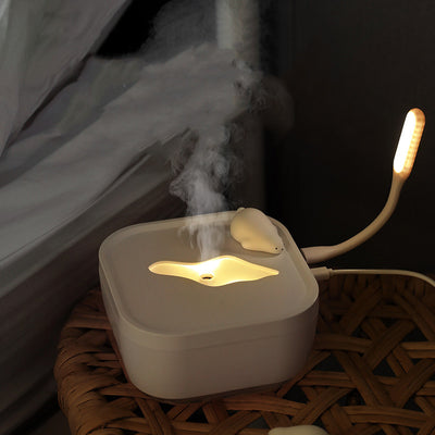 White ultrasonic humidifier with a clear base and a cute polar bear figurine on top, emitting a fine mist. - Image 9
