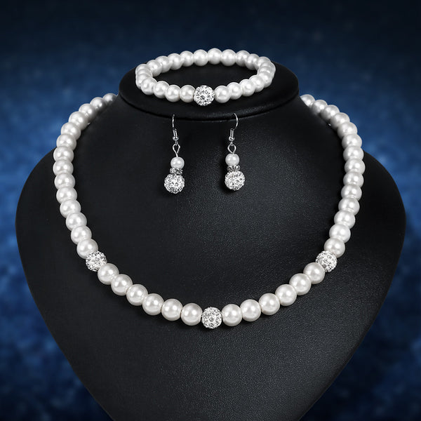 White faux pearl necklace, bracelet, and dangle earrings set with pave crystal beads on a black display.