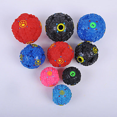 Blue rubber dog toy ball with bone-shaped nubs, red dots, and yellow paw print accents, designed for treats.