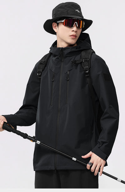 Man wearing a black windproof and waterproof outdoor jacket with a hood, sports sunglasses, and a bucket hat, holding a trekking pole. - Image 8