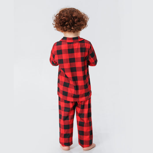Baby in a red and black buffalo plaid long-sleeve pajama romper, viewed from the back with arms raised. - Image 22