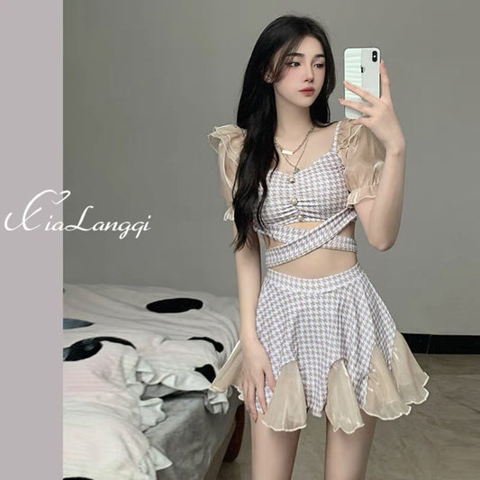 Women's conservative two-piece swimsuit with beige and white houndstooth pattern, sheer puff sleeves, and a flared skirt.