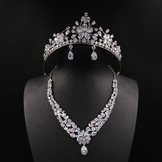 Sparkling bridal jewelry set with a silver-tone crown, necklace, and teardrop earrings, adorned with clear crystals.