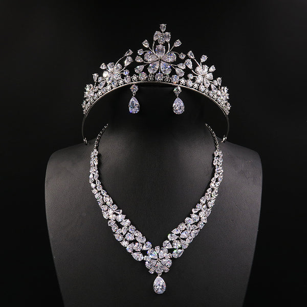Sparkling bridal jewelry set with a silver-tone crown, necklace, and teardrop earrings, adorned with clear crystals.
