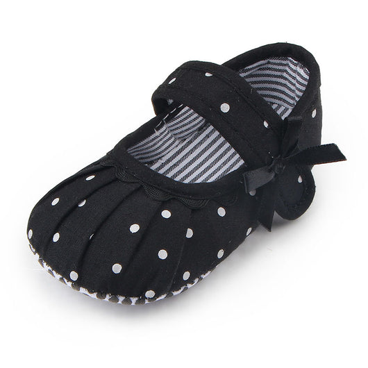 Black baby girl Mary Jane shoes with white polka dots, a strap, bow accent, and striped lining. - Image 2