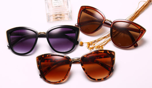 Black cat-eye sunglasses for women with gradient grey lenses and subtle gold-tone metal accents on the frame. - Image 13