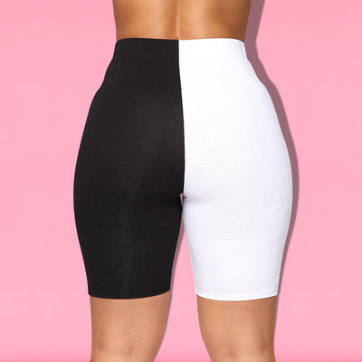 Woman wearing a black and white color-block long-sleeve top and matching shorts with white sneakers. - Image 29