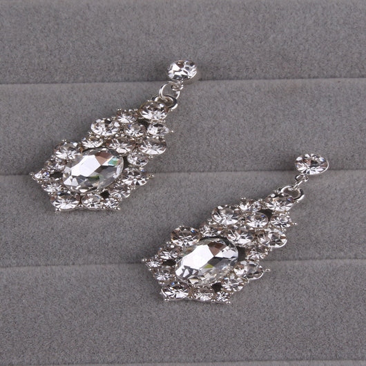 Sparkling silver-tone necklace and matching dangle earrings set, adorned with numerous clear crystals and large oval center stones. - Image 5
