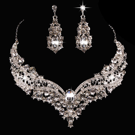 Sparkling silver-tone necklace and matching dangle earrings set, adorned with numerous clear crystals and large oval center stones.