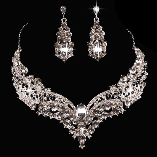 Sparkling silver-tone necklace and matching dangle earrings set, adorned with numerous clear crystals and large oval center stones.