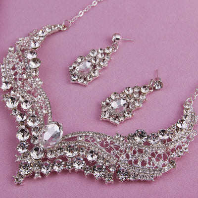 Sparkling silver-tone necklace and matching dangle earrings set, adorned with numerous clear crystals and large oval center stones. - Image 4
