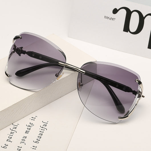 Oversized rimless sunglasses with gradient gray lenses and silver-tone metal accents, displayed on a white surface. - Image 11