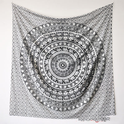 Black and white mandala tapestry with string lights hanging above a bed with blue and white patterned pillows. - Image 11