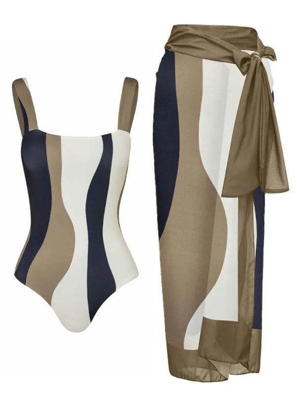 Green and white abstract wavy print one-piece swimsuit with matching sarong, offering conservative belly coverage.