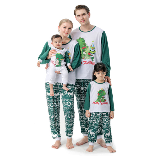 Woman in a Christmas pajama set with a white top, green sleeves, dinosaur graphic, and green fair isle pants. - Image 2