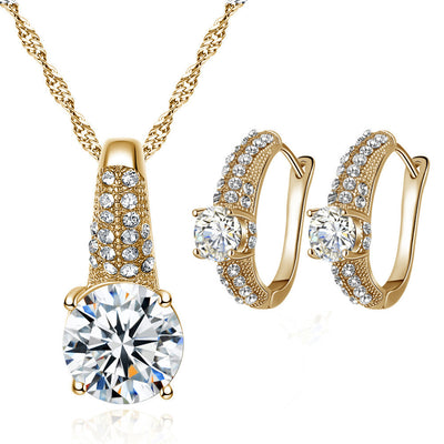 Gold-toned bridal necklace and hoop earrings set with large round cubic zirconia stones and pave accents.