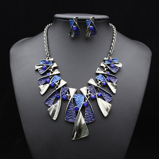Silver and blue abstract fashion necklace and matching stud earrings set with blue rhinestones on a black mannequin. - Image 7