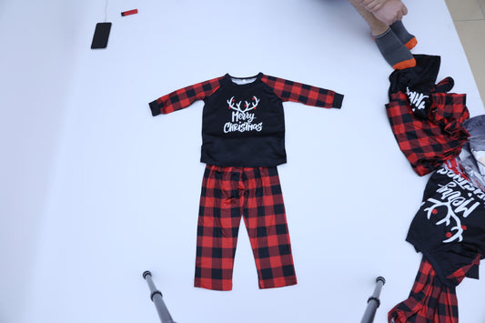 Black and red buffalo plaid pajama set with 'Merry Christmas' and reindeer antlers on the long-sleeved top.