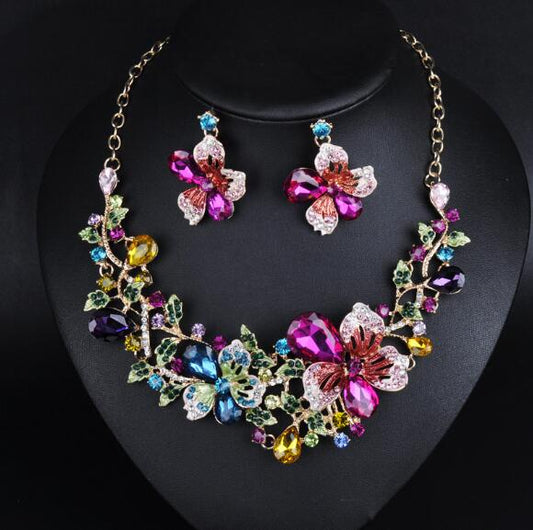 Gold-tone statement necklace and matching stud earrings with multi-colored crystal floral design. - Image 2