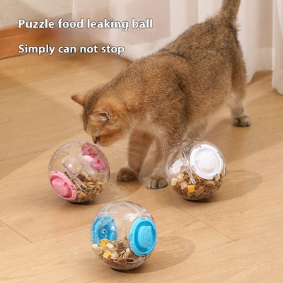 Clear plastic pet tumbler food leakage toy with blue accents and a cat face design, on a wooden floor.