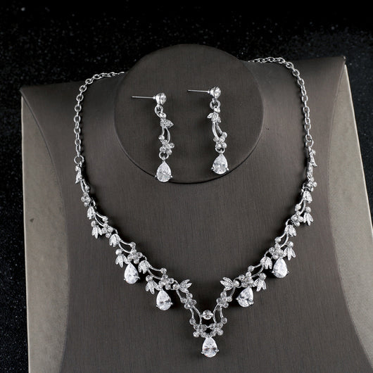 Silver-toned necklace and dangle earrings set with clear teardrop and round cubic zirconia stones in a floral design.