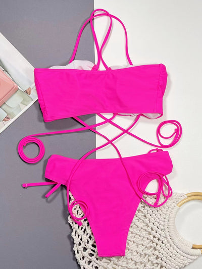 Neon pink lace-up bikini with a bandeau top and high-cut bottom, laid flat on a split gray and white background. - Image 10