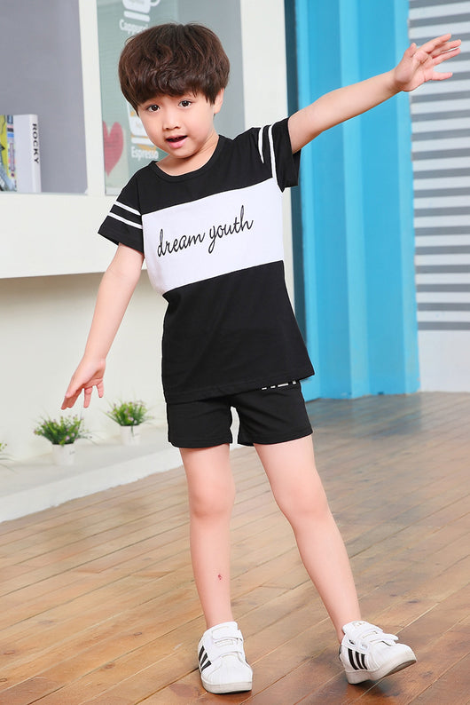 Young girl in a white short-sleeve t-shirt with a black stripe and black shorts, wearing a black cap. - Image 24