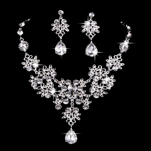 Purple crystal necklace and earring set with butterfly and floral designs, featuring large teardrop pendants.