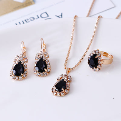 Red teardrop rhinestone necklace, matching dangle earrings, and adjustable ring set in gold-tone metal. - Image 2