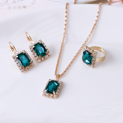 Gold-toned three-piece jewelry set with rectangular clear crystal necklace, matching drop earrings, and adjustable ring. - Image 6