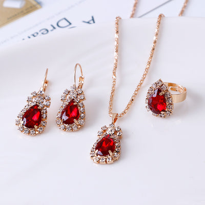 Red teardrop rhinestone necklace, matching dangle earrings, and adjustable ring set in gold-tone metal. - Image 5
