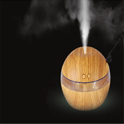 Spherical wood grain humidifier with a clear band, emitting mist, against a dark background with lotus flowers. - Image 6
