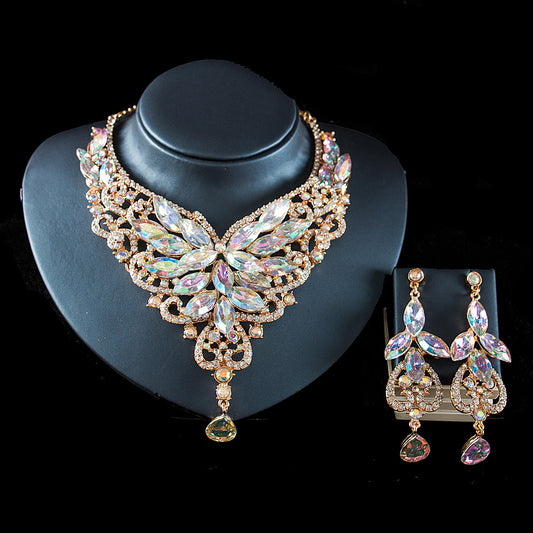 Exaggerated green gemstone necklace and matching dangle earrings set with gold-tone metal and clear accents.