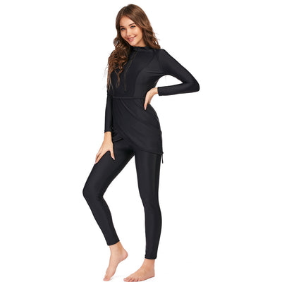 Woman wearing a black conservative Muslim swimsuit with a long-sleeved top, draped peplum, leggings, and swim turban. - Image 5