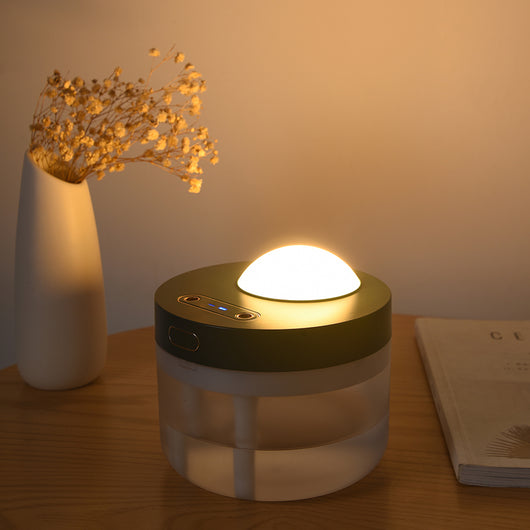 White portable projection humidifier with a translucent water tank and gold-accented control buttons. - Image 3