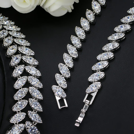 Silver-toned necklace and earring set with red teardrop stones and clear marquise-cut accents on a black display. - Image 4
