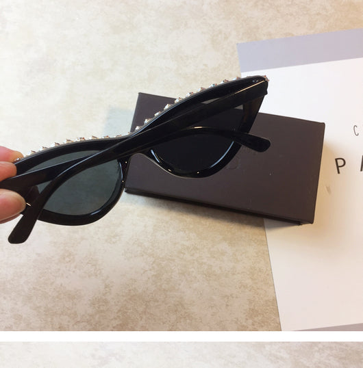 Two pairs of cat-eye sunglasses, one black with clear rhinestones and one pink with pink rhinestones, on a light surface. - Image 8